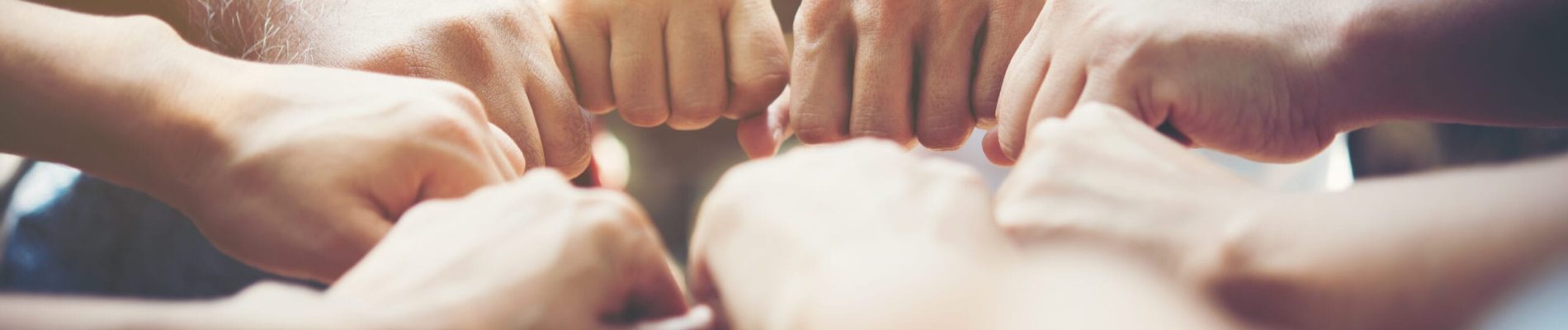 Close up of young people putting their hands together. Team with stack of hands showing unity and teamwork.